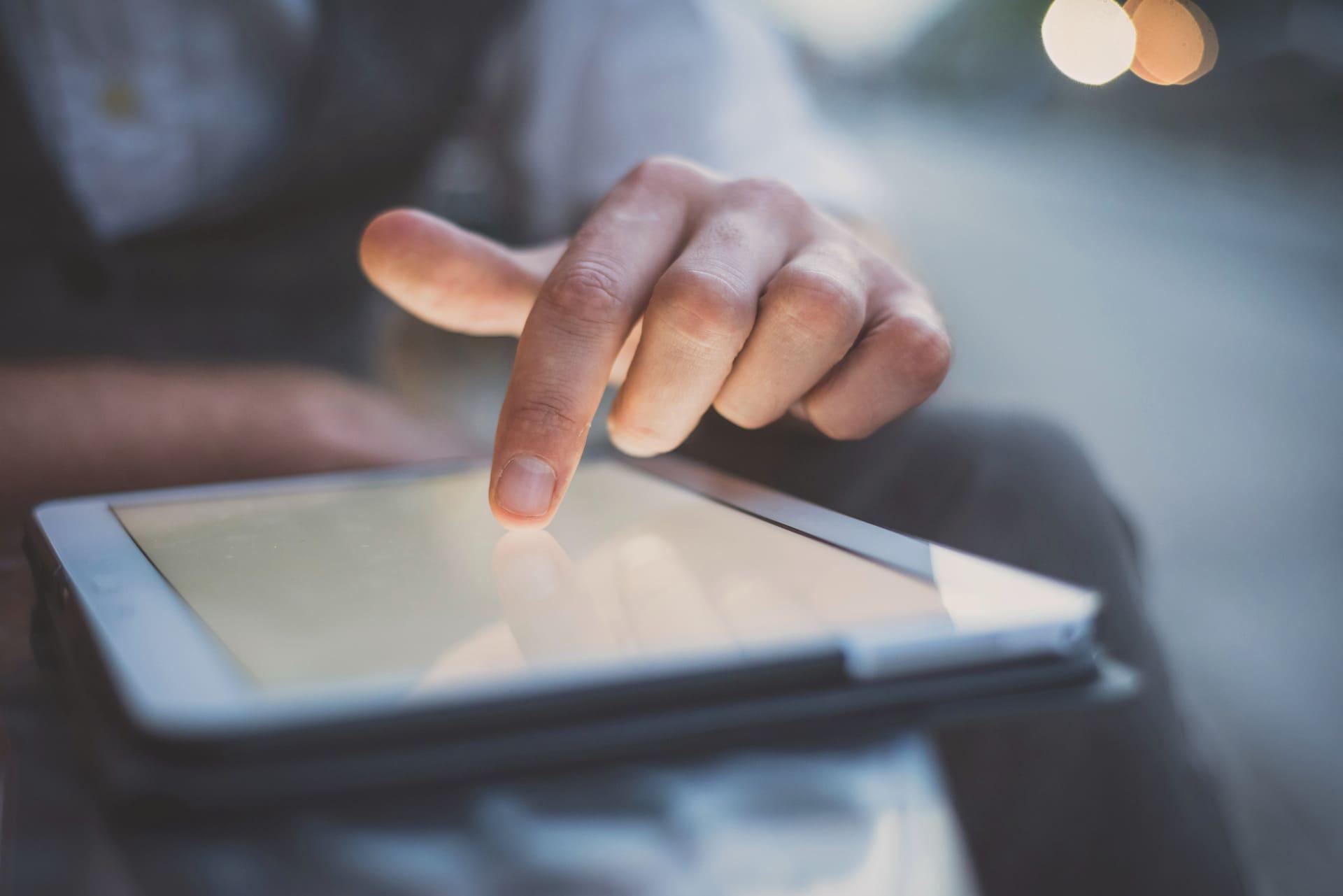 Persona tocando la pantalla de una tablet