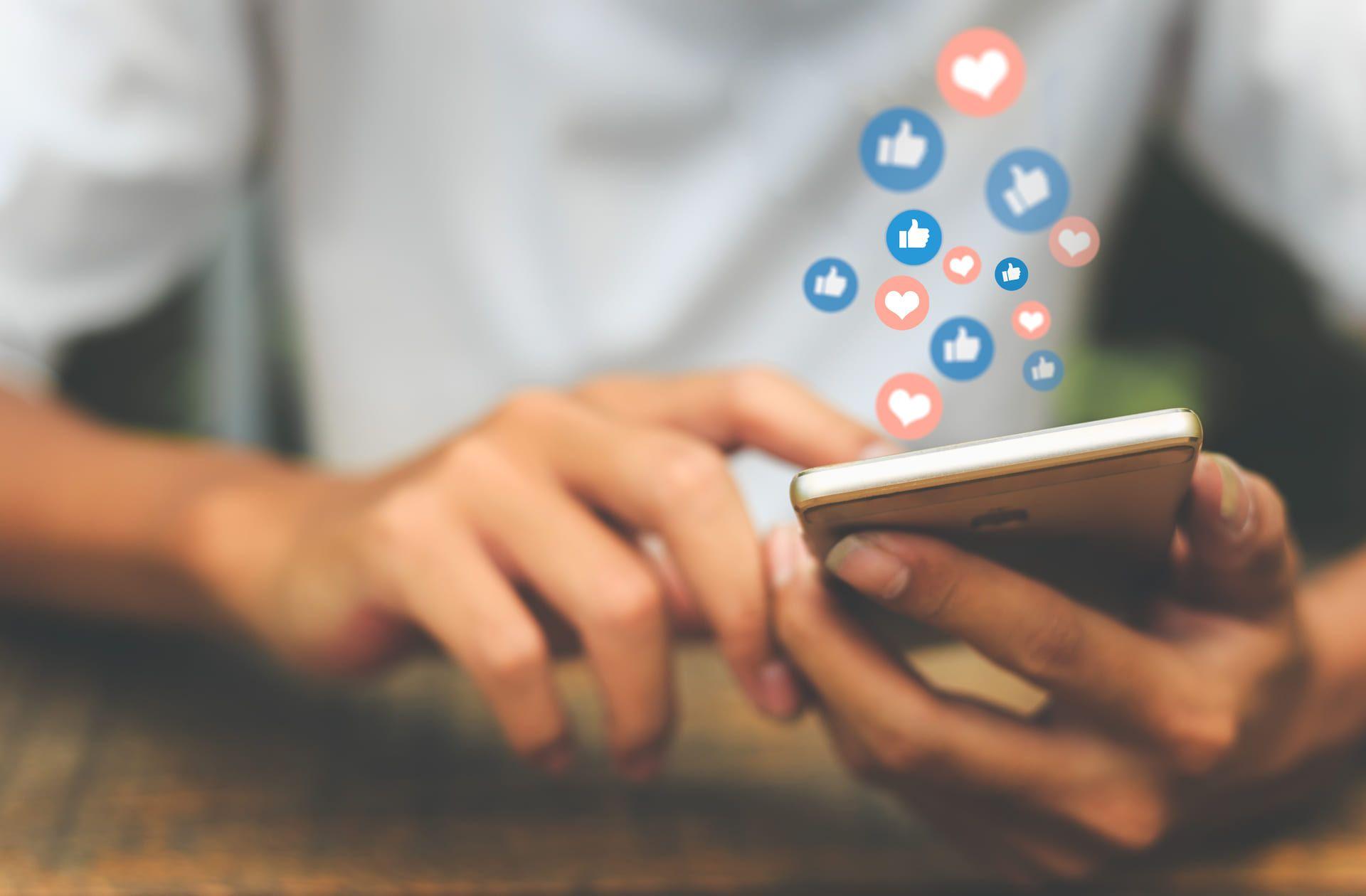 Persona con un teléfono en sus manos, revisando las redes sociales